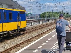 Man met kinderwagen op perron