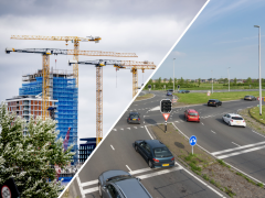 Flatgebouwen met bouwkranen en een rotonde met auto's